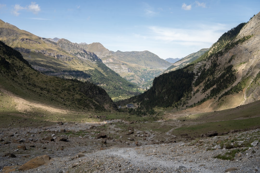 Sunlit valley between rugged mountains under a blue sky