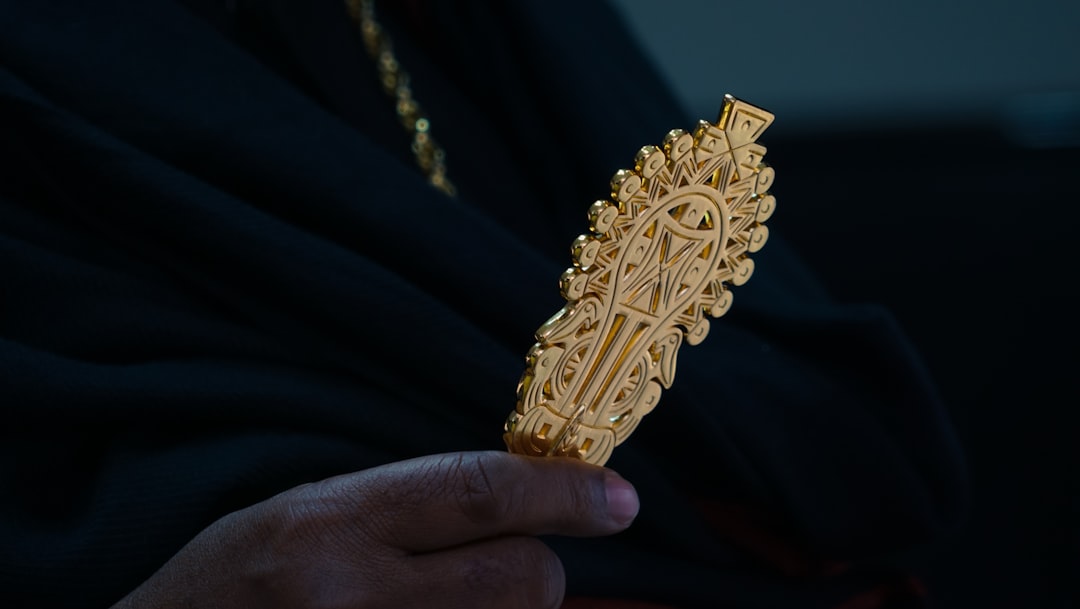 a hand holding a gold chain